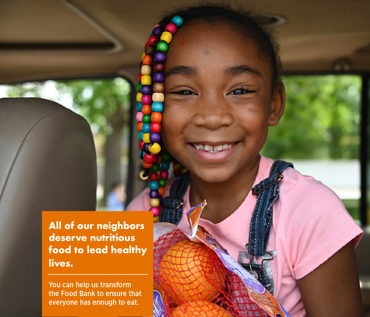 Smiling girl holding a bag of oranges