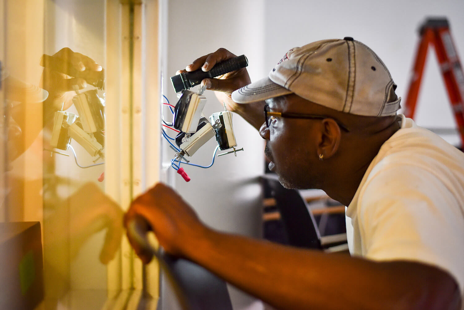 A man investigating a technology issue with a flashlight
