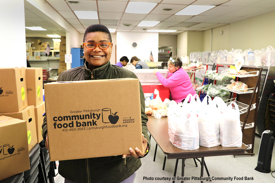 Woman holding a box of food for the community food bank